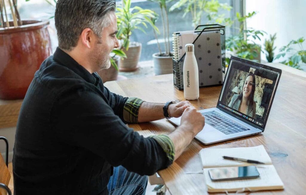 A man talking on Zoom with a woman